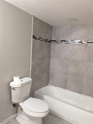 a white toilet and tub sitting next to a bathroom sink