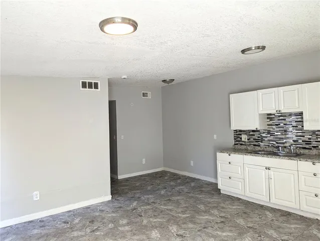 a kitchen with granite countertop a sink and a stove