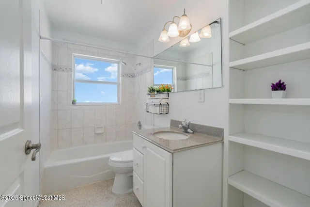 a bathroom with a granite countertop sink a toilet and shower