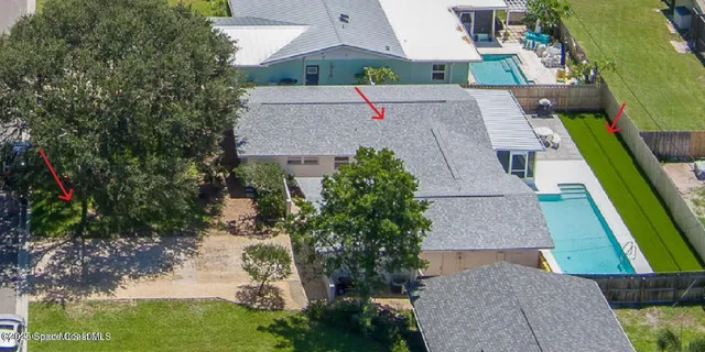 an aerial view of a house with a yard and greenery