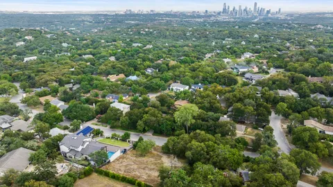 an aerial view of a house with garden space and trees