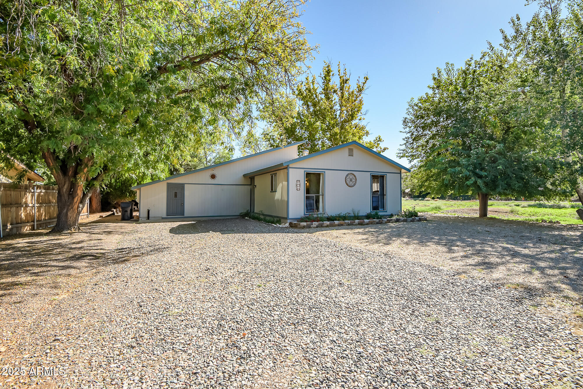 a view of a house with a yard and large tree