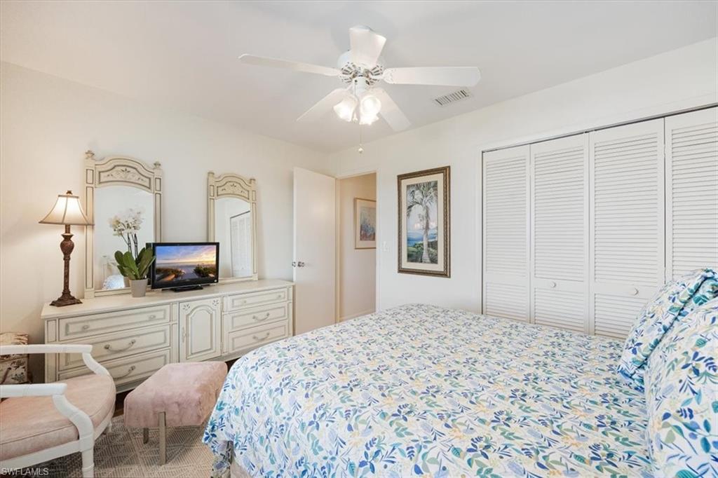 315 St Andrews Boulevard, Unit D37 Naples, FL 34113 - Photo 18 of 31 a bedroom with a bed and a chandelier