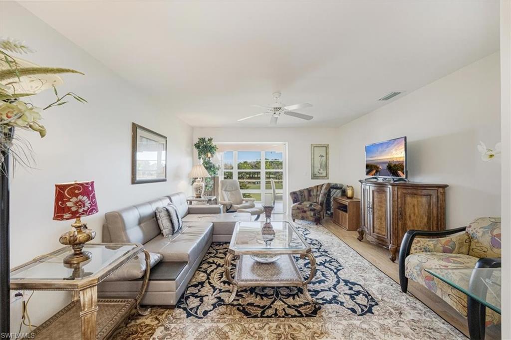 315 St Andrews Boulevard, Unit D37 Naples, FL 34113 - Photo 7 of 31 a living room with furniture wooden floor and a large window
