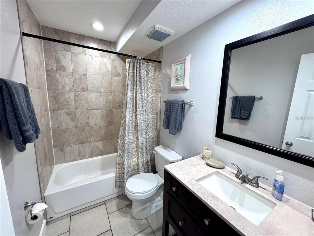 3473 Clark Road, Unit 171 Sarasota, FL 34231 - Photo 15 of 22 a bathroom with a granite countertop sink a toilet a mirror a vanity and bathtub