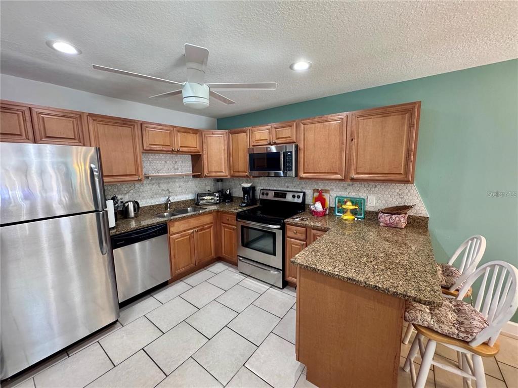 3473 Clark Road, Unit 171 Sarasota, FL 34231 - Photo 5 of 22 a kitchen with granite countertop a refrigerator stove top oven and sink