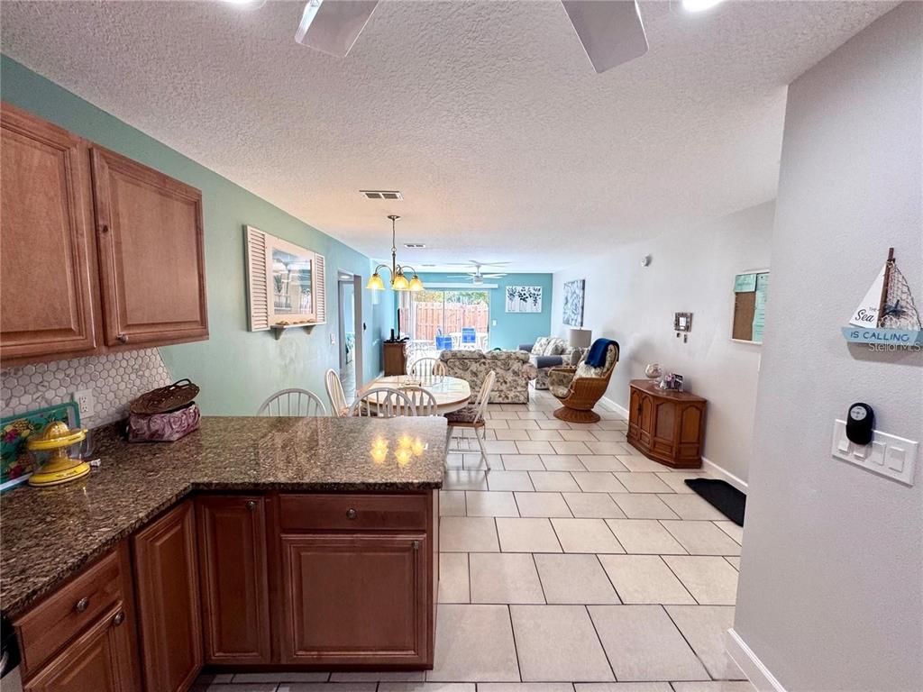 3473 Clark Road, Unit 171 Sarasota, FL 34231 - Photo 7 of 22 a kitchen with granite countertop a stove and white cabinets