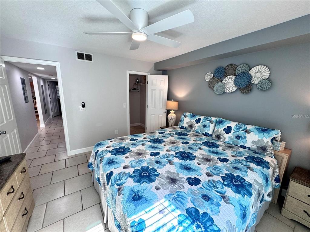 3473 Clark Road, Unit 171 Sarasota, FL 34231 - Photo 9 of 22 a bedroom with a large bed and a chandelier