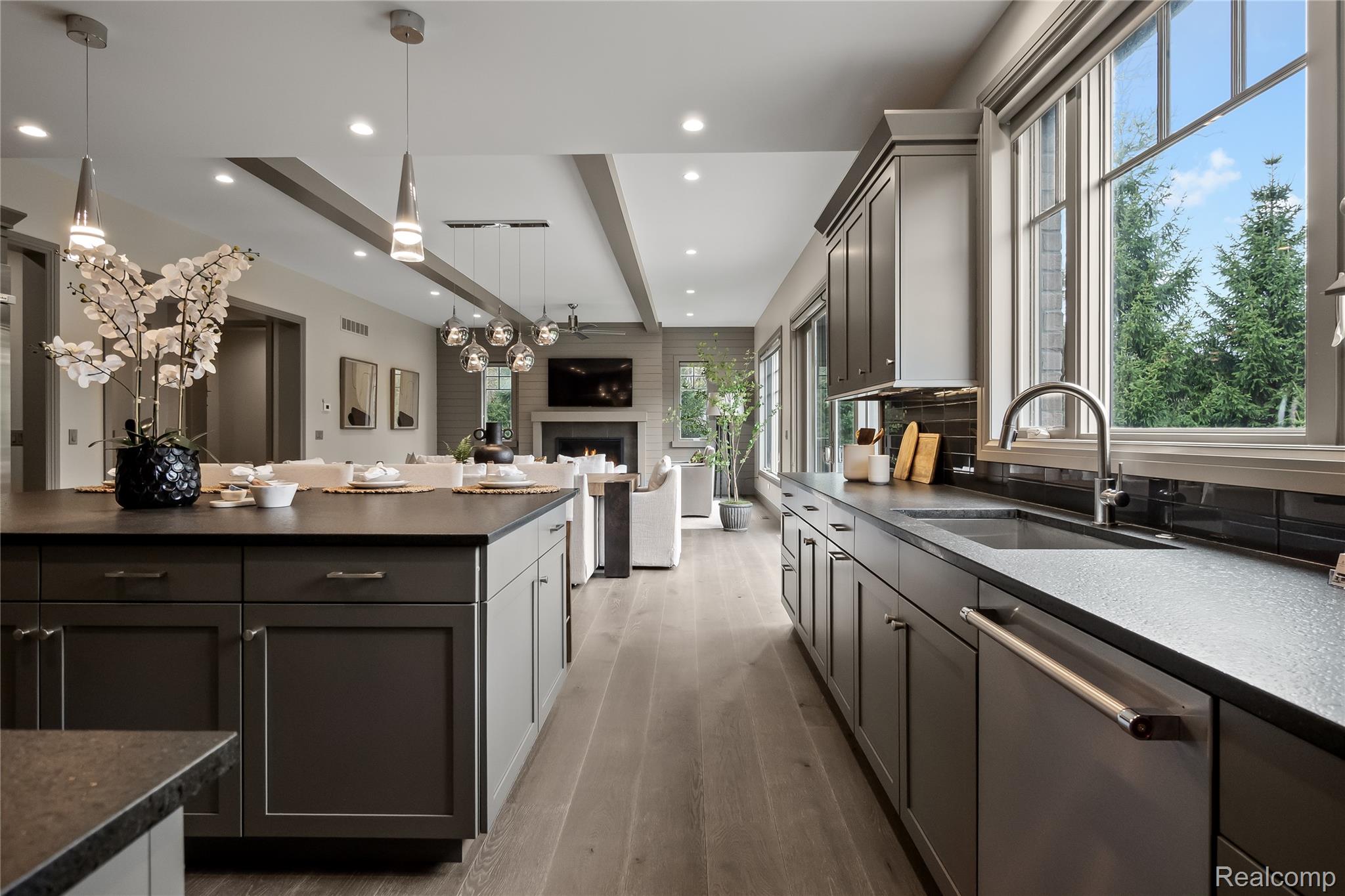 3824 Poppleton Street Troy, MI 48084 - Photo 13 of 51 Kitchen with a warm lit fireplace, stainless steel dishwasher, a ceiling fan, two tone color scheme, and beam ceiling