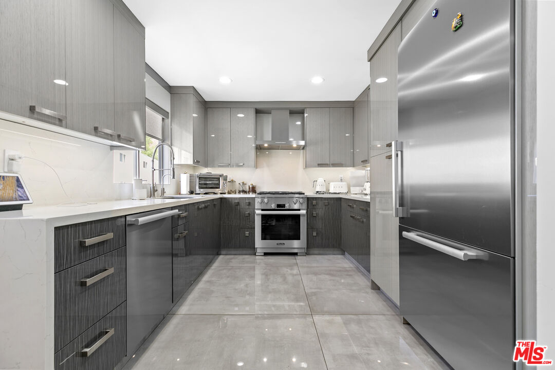 9772 Vía Roma Burbank, CA 91504 - Photo 11 of 44 a kitchen with a sink stainless steel appliances and cabinets