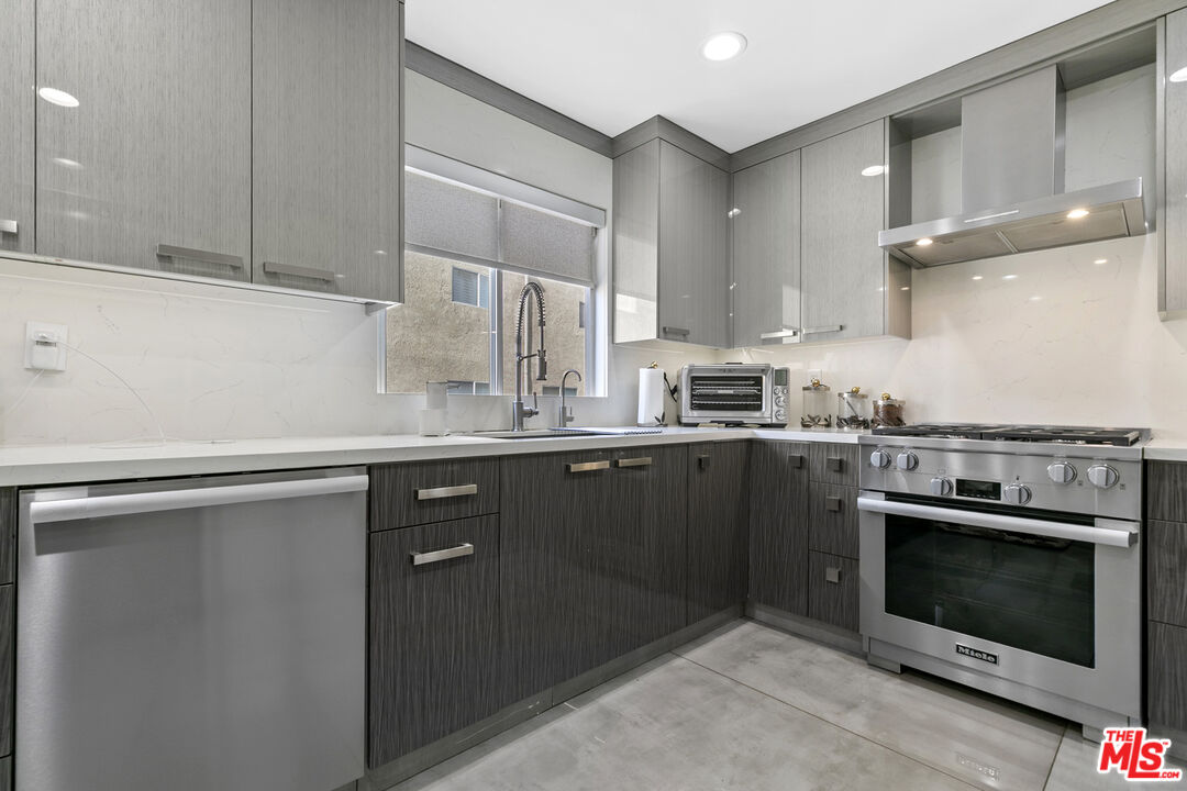 9772 Vía Roma Burbank, CA 91504 - Photo 13 of 44 a kitchen with stainless steel appliances granite countertop a stove a sink and a microwave