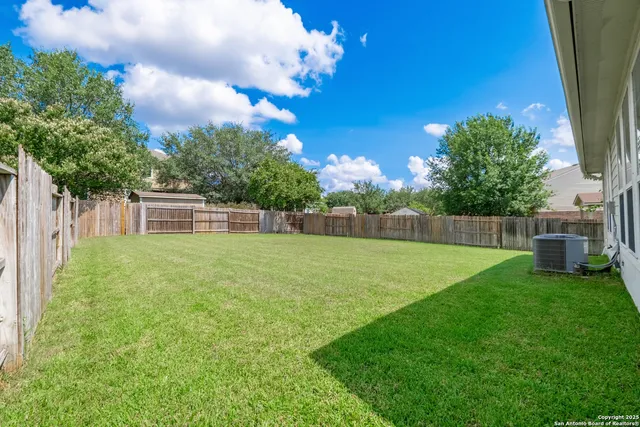 a house that has a big yard with wooden fence
