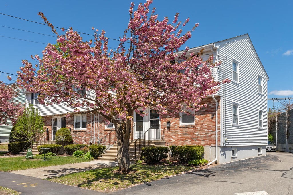 84 Lancaster Road, Unit 84 Dedham, MA 02026 - Photo 2 of 23 a front view of a house with a yard