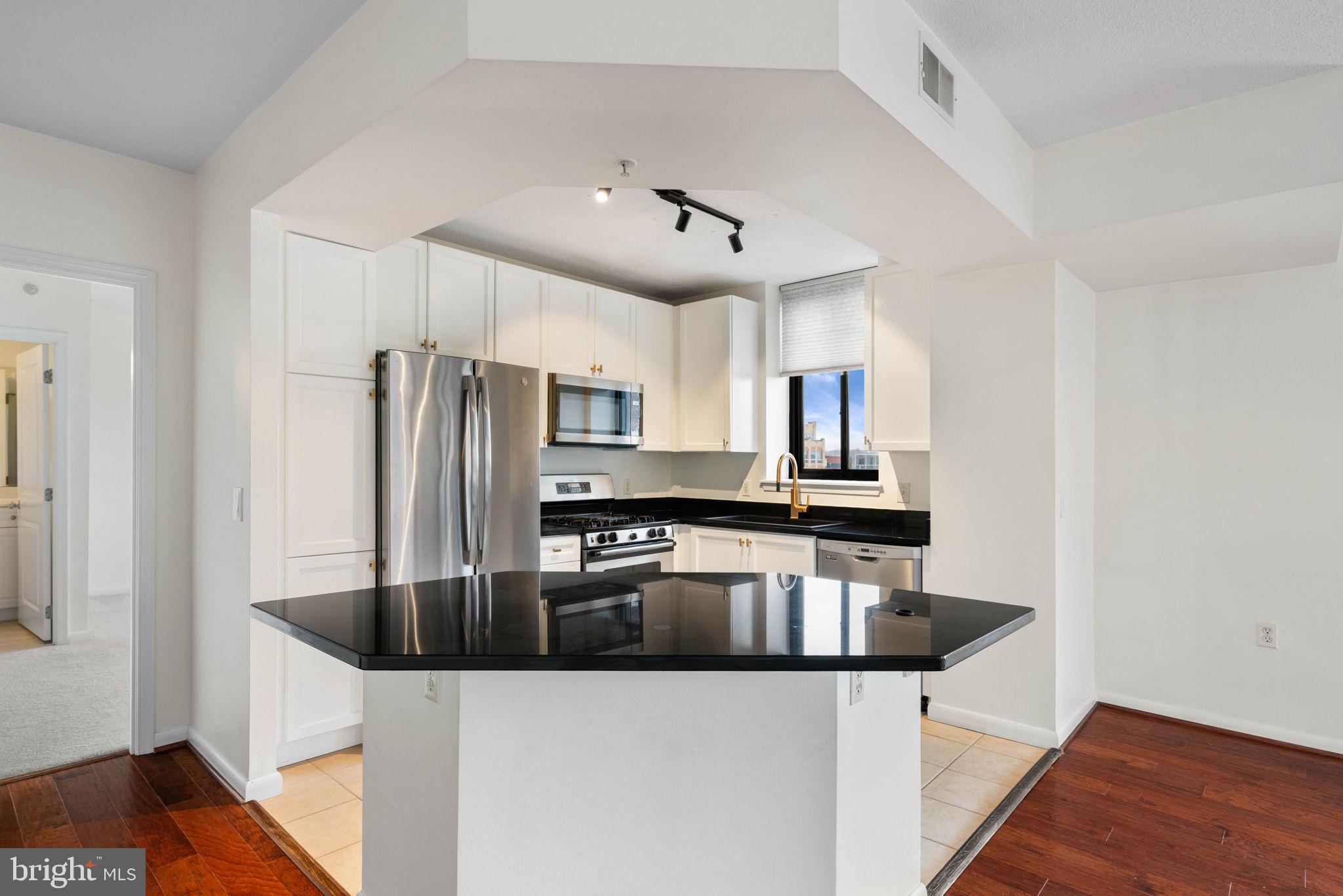 851 North Glebe Road, Unit 1011 Arlington, VA 22203 - Photo 12 of 41 a kitchen with stainless steel appliances granite countertop a sink a stove and refrigerator