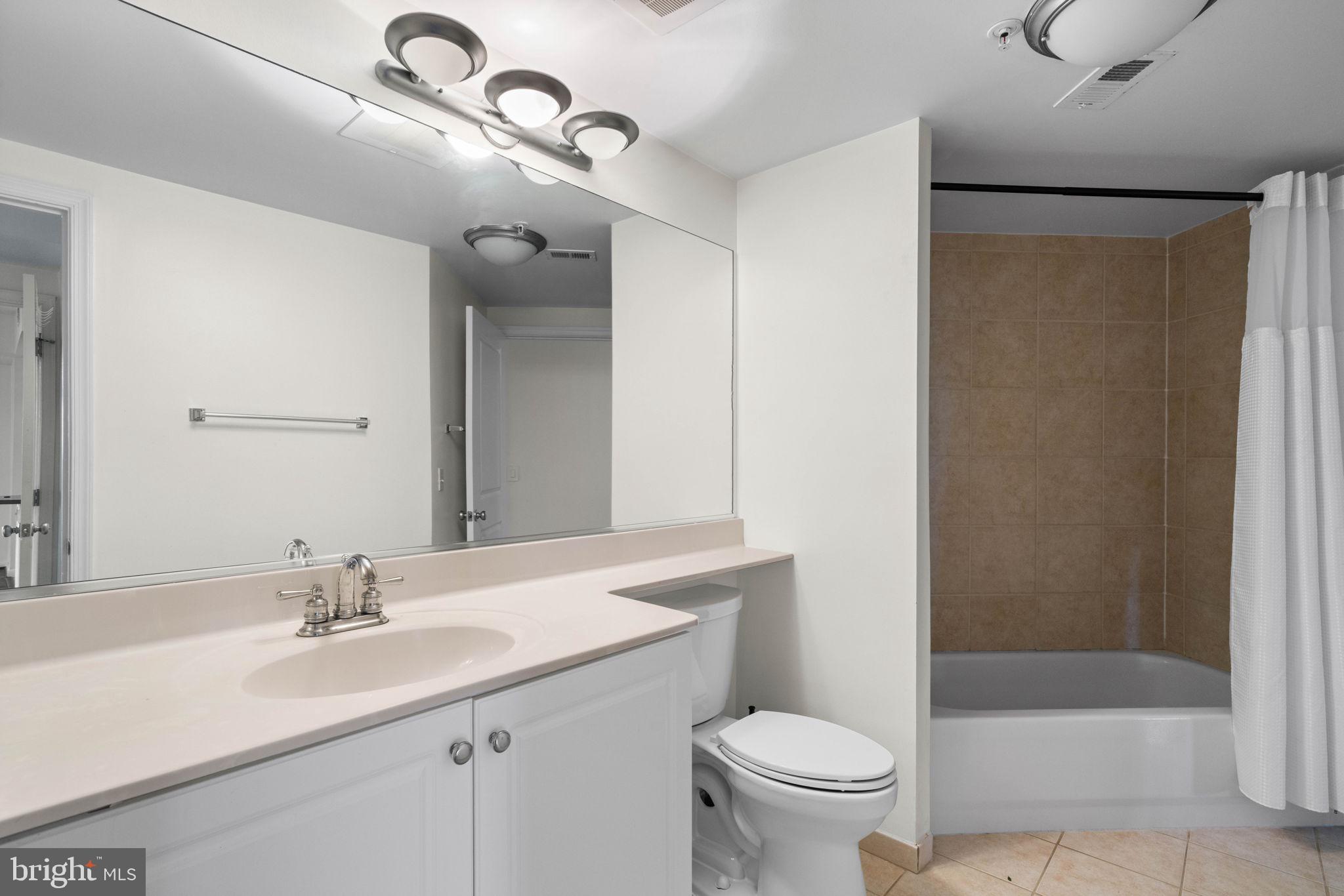 851 North Glebe Road, Unit 1011 Arlington, VA 22203 - Photo 23 of 41 a bathroom with a granite countertop sink a toilet and a mirror