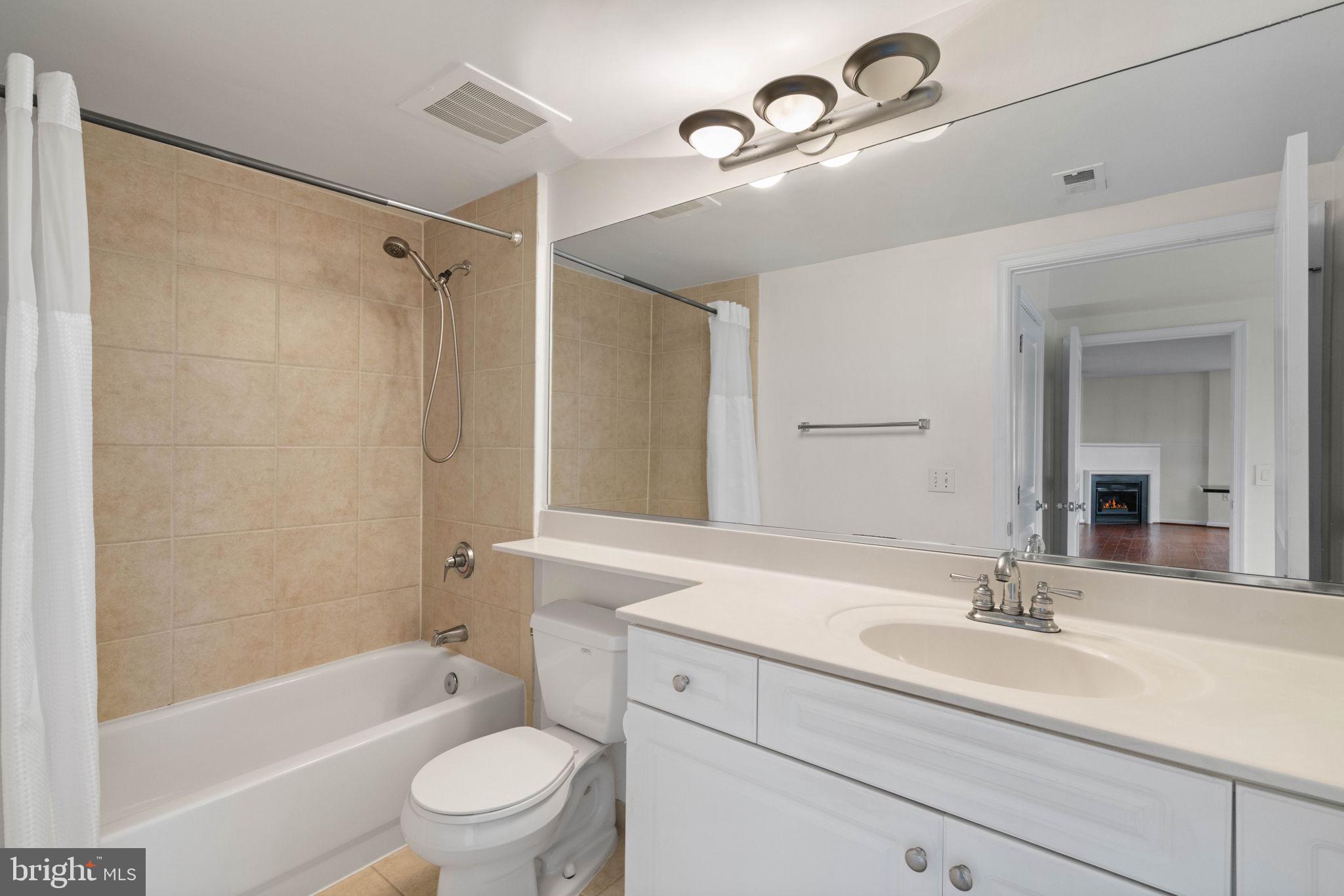 851 North Glebe Road, Unit 1011 Arlington, VA 22203 - Photo 29 of 41 a bathroom with a granite countertop sink a toilet a mirror and shower