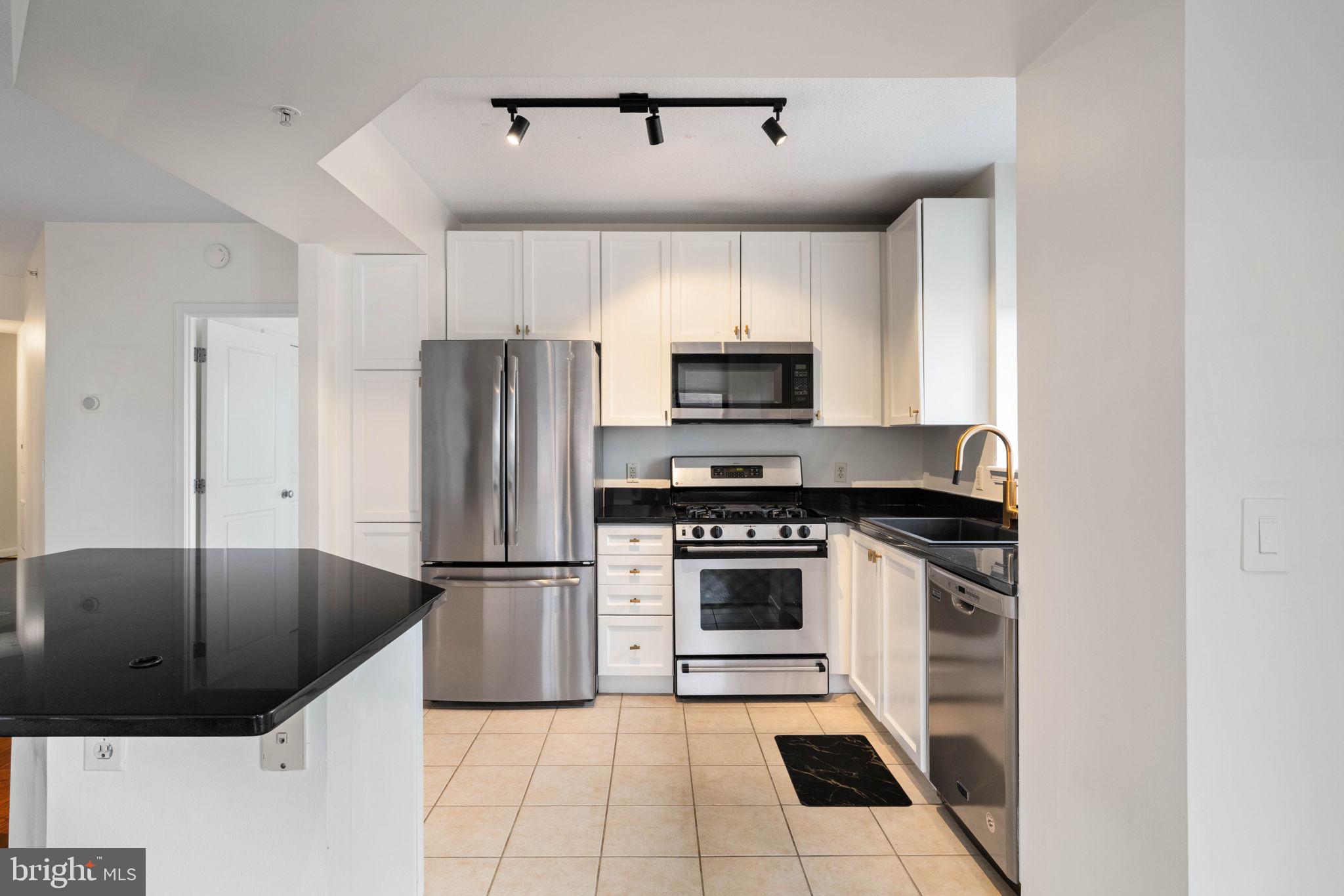 851 North Glebe Road, Unit 1011 Arlington, VA 22203 - Photo 10 of 41 a kitchen with granite countertop a sink stainless steel appliances and counter space
