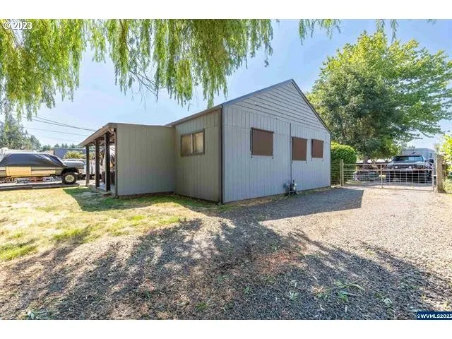 a backyard of a house with wooden fence and large trees