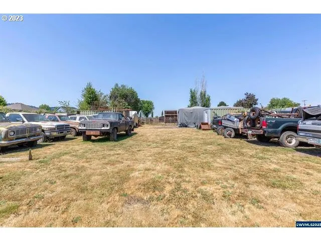 a car parked in the yard next to a road