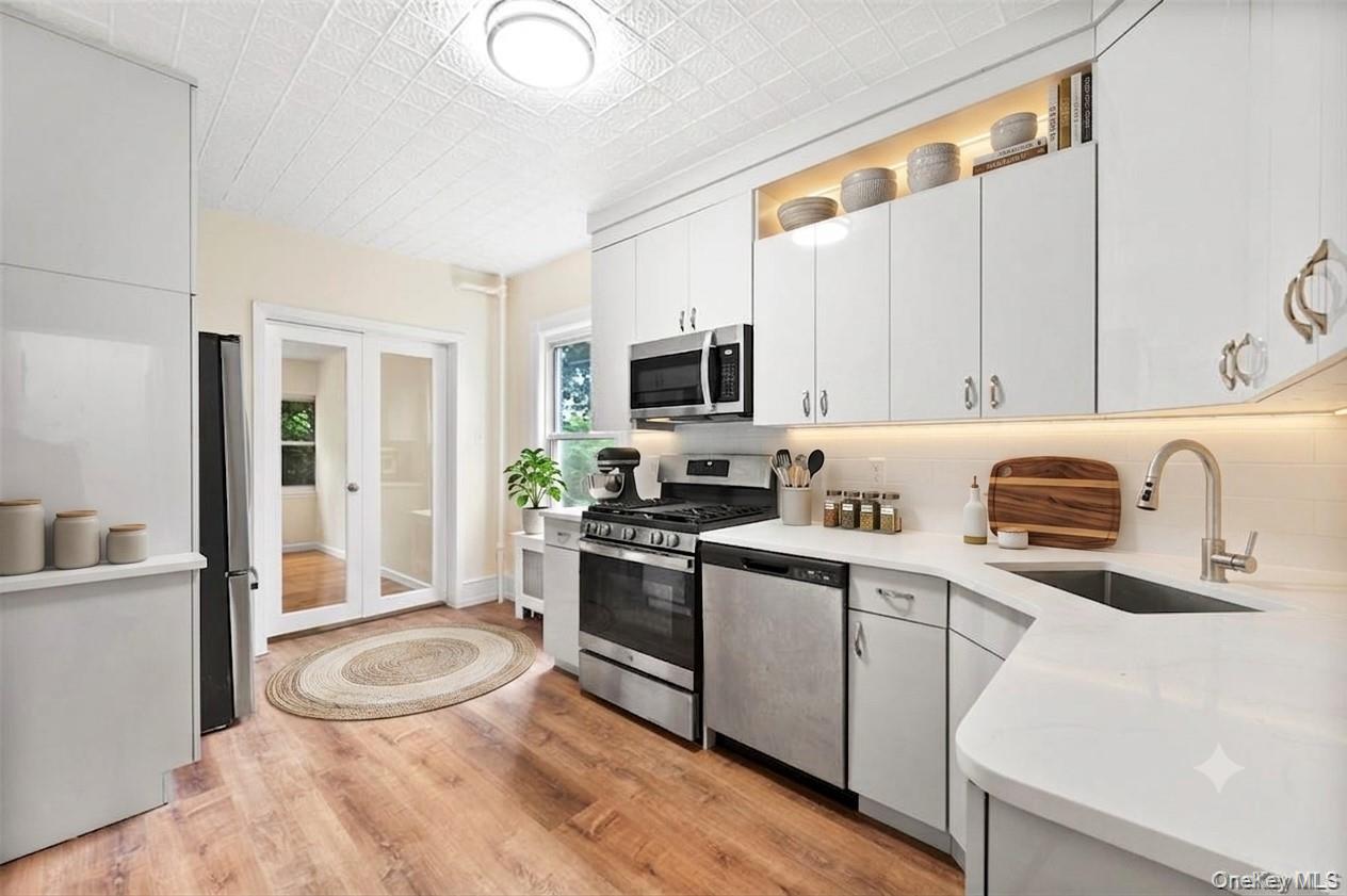 91 Parkway Road, Unit G1 Bronxville, NY 10708 - Photo 6 of 28 a kitchen with stainless steel appliances a sink a stove a refrigerator cabinets and a dining table