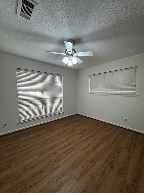 3205 Pin Oak Drive Temple, TX 76502 - Photo 22 of 30 an empty room with wooden floor chandelier fan and windows