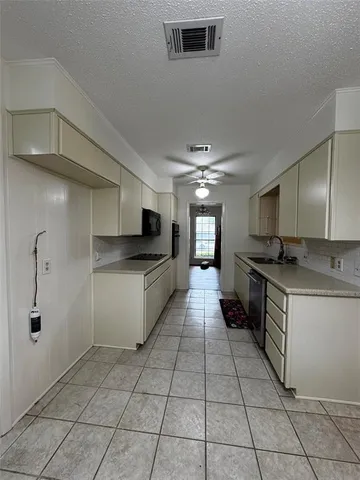 a large kitchen with a stove a sink dishwasher and a refrigerator