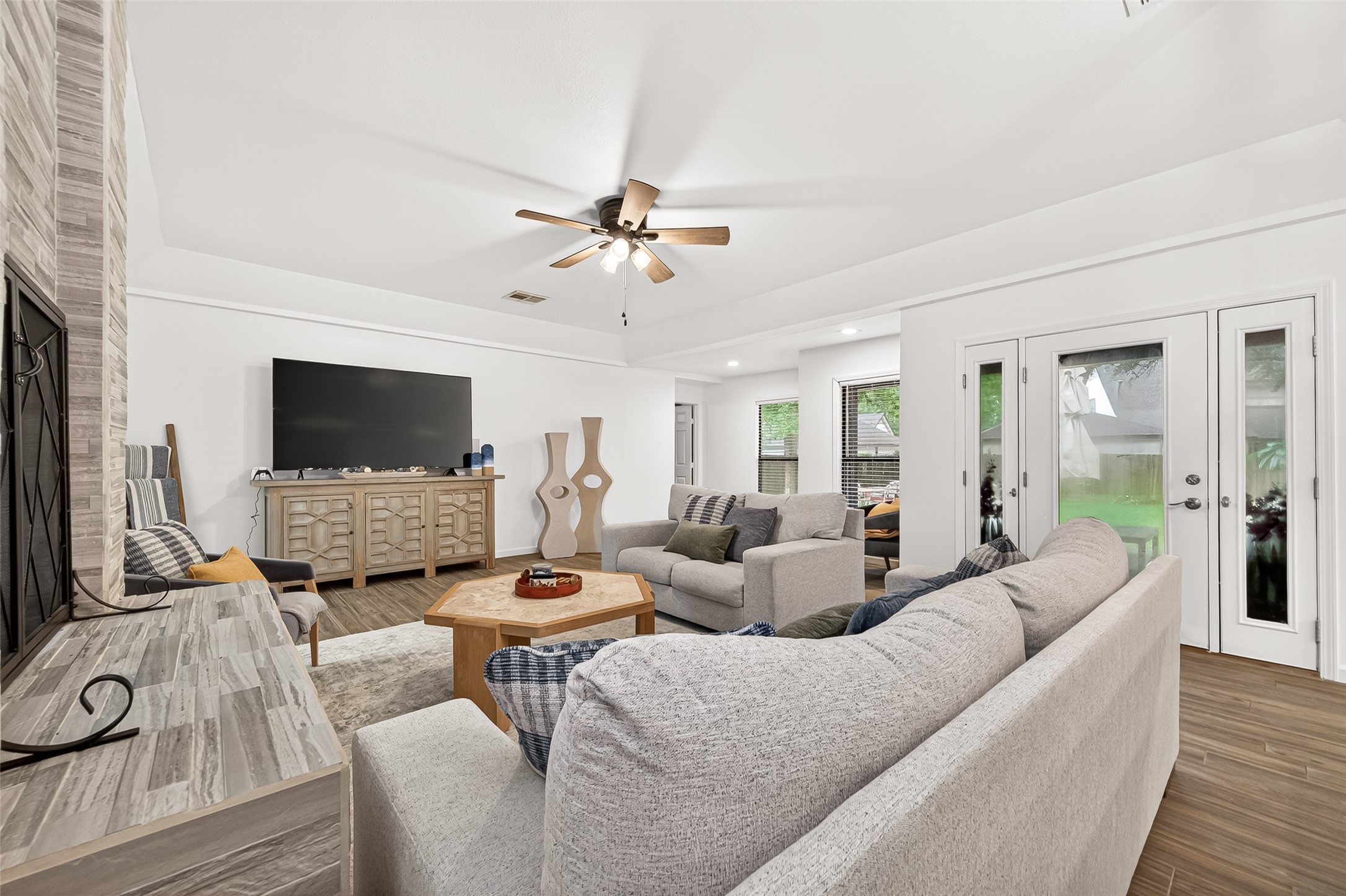 548 Brandon Road Conroe, TX 77302 - Photo 4 of 37 Bright and inviting open concept living room featuring wood like tile flooring, abundant windows for natural light and furnished in modern tones that create a warm and welcoming atmosphere.