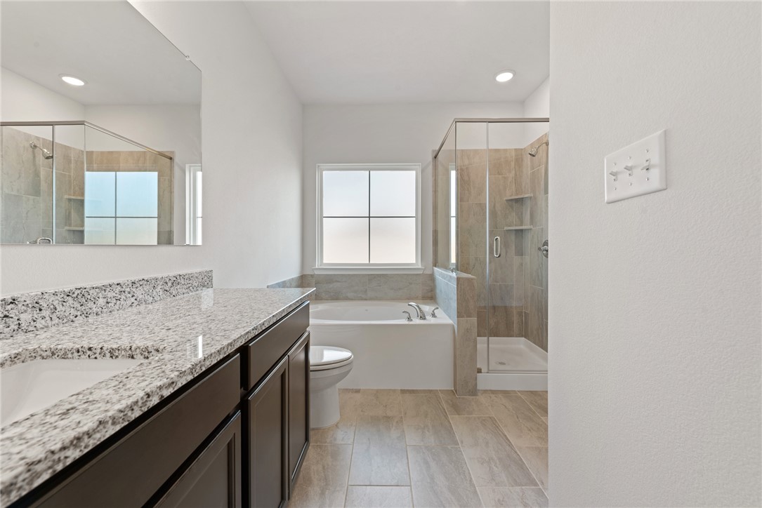 2412 Rooke Road Bryan, TX 77807 - Photo 24 of 35 a bathroom with a granite countertop sink a toilet and shower