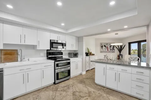 a kitchen with granite countertop a stove sink and cabinets