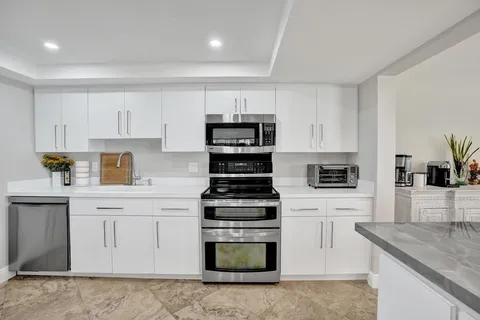 a kitchen with cabinets stainless steel appliances and window