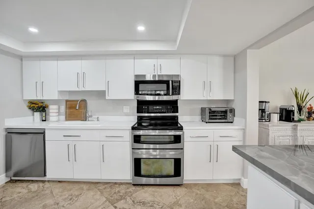 a kitchen with cabinets stainless steel appliances and window