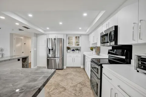 a kitchen with stainless steel appliances granite countertop a refrigerator and a sink