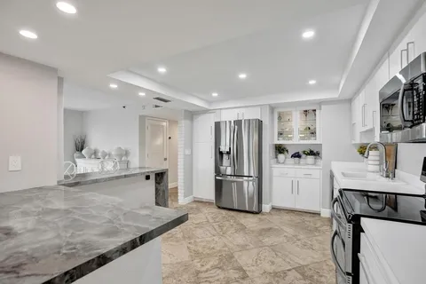 a kitchen with stainless steel appliances granite countertop a stove refrigerator sink and cabinets