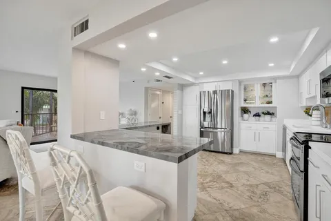 a kitchen with counter top space cabinets and living room
