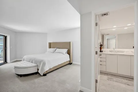 a bedroom with a white bed and flat screen tv