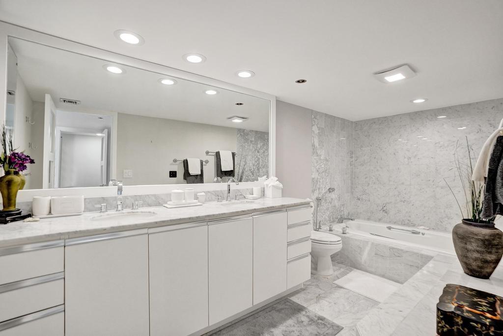 501 North Riverside Drive, Unit 203 Pompano Beach, FL 33062 - Photo 32 of 63 a bathroom with a double vanity sink a toilet and a mirror