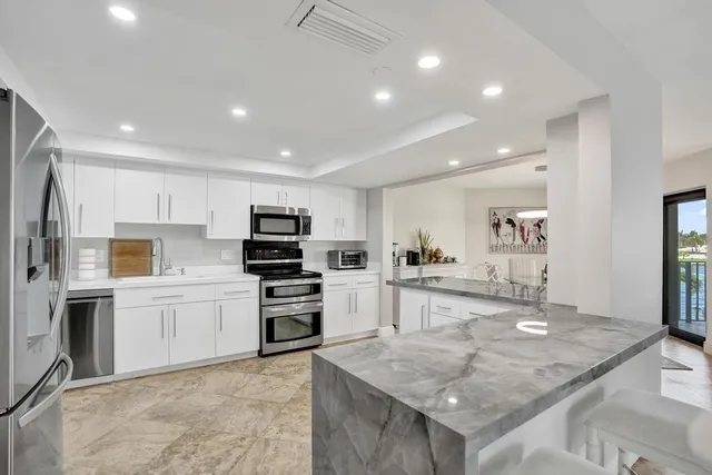 a kitchen with granite countertop a refrigerator and a sink