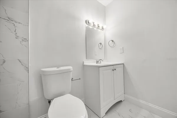 a bathroom with a toilet a sink and mirror