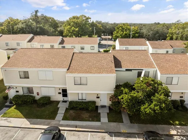 an aerial view of a house with yard and mountain view in back