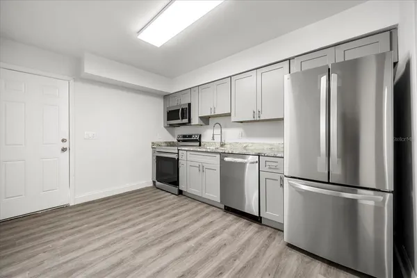 a kitchen with a refrigerator a sink and a stove top oven