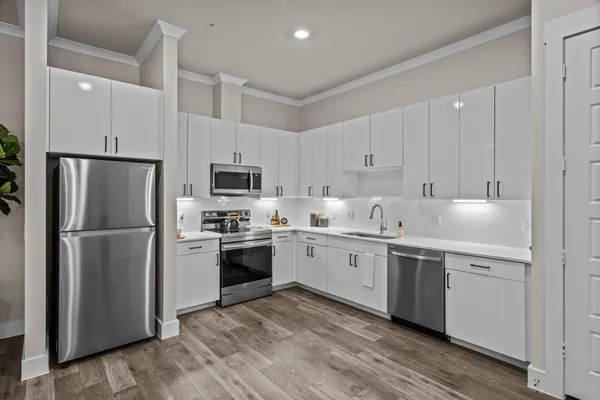 a kitchen with stainless steel appliances granite countertop a refrigerator sink and stove