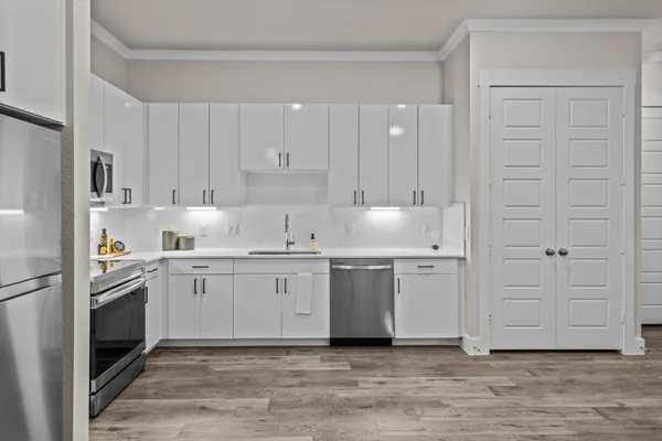 a kitchen with white cabinets and stainless steel appliances