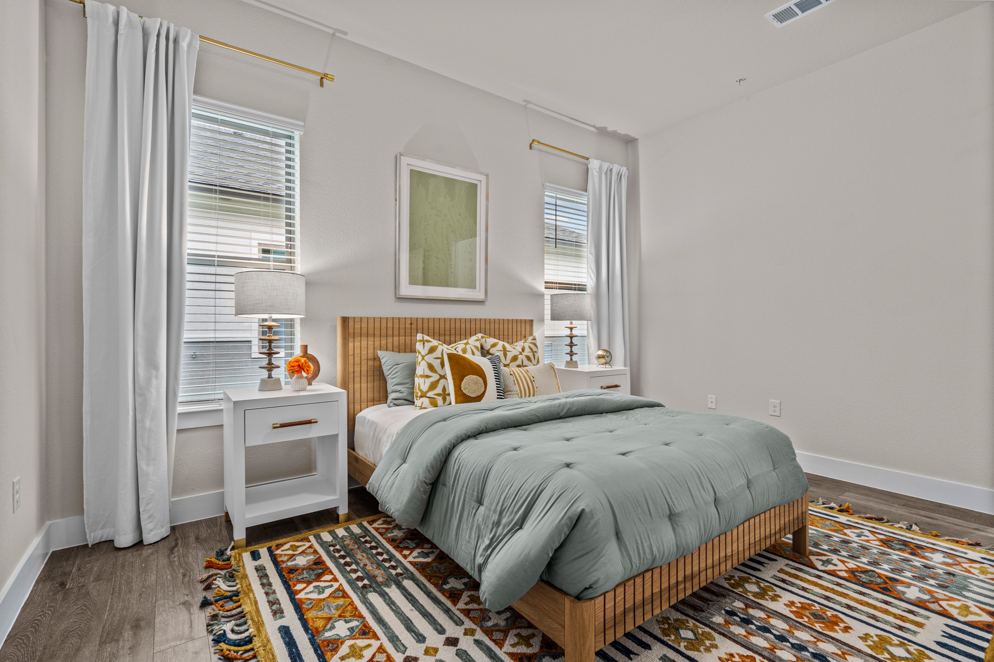 865 Limmer Loop, Unit 1105 Hutto, TX 78634 - Photo 17 of 32 a bedroom with a bed and wooden floor