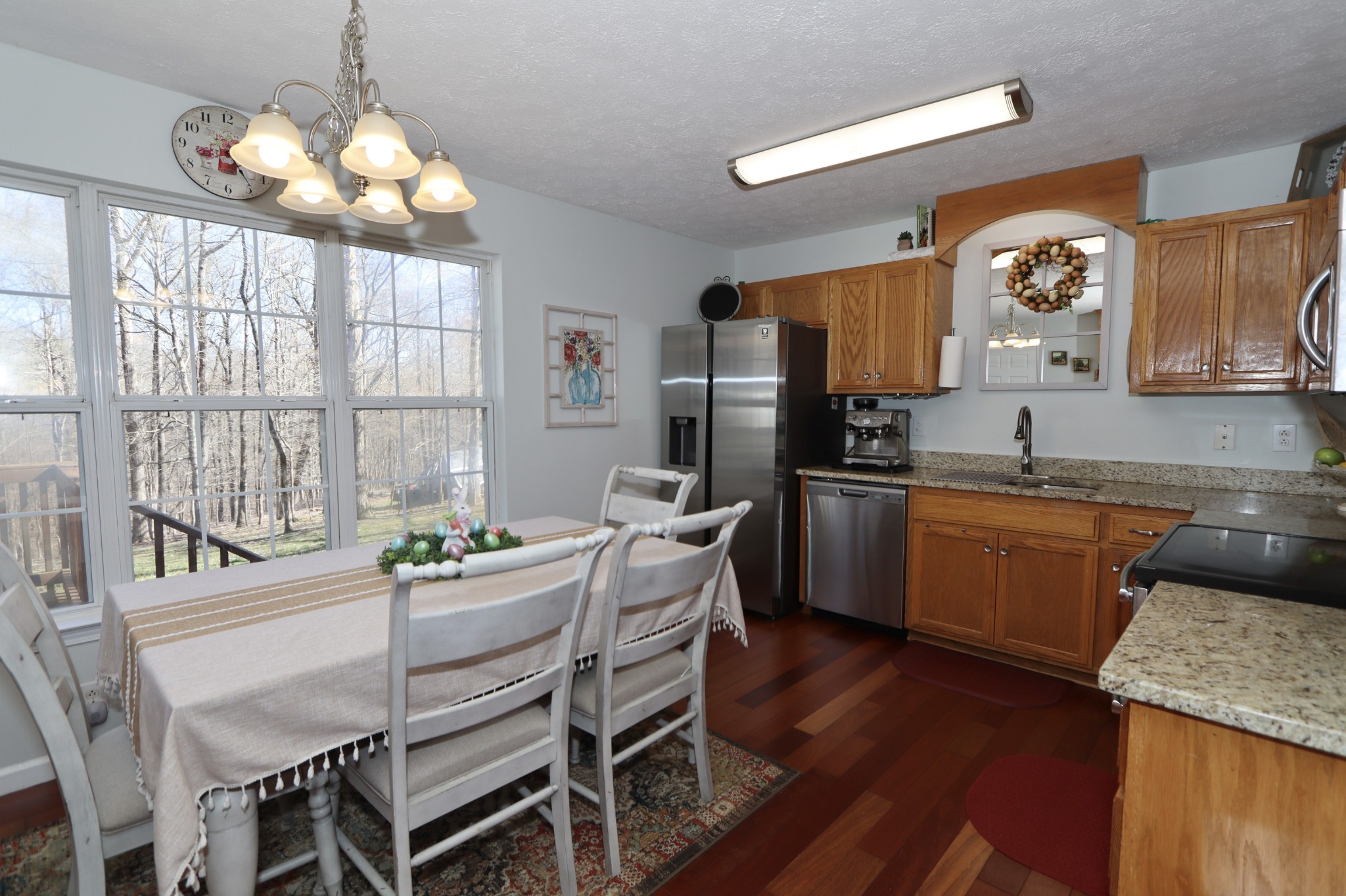 972 Williamson County Line Road Fairview, TN 37062 - Photo 6 of 68 a kitchen with granite countertop a stove a sink dishwasher a dining table and chairs with wooden floor