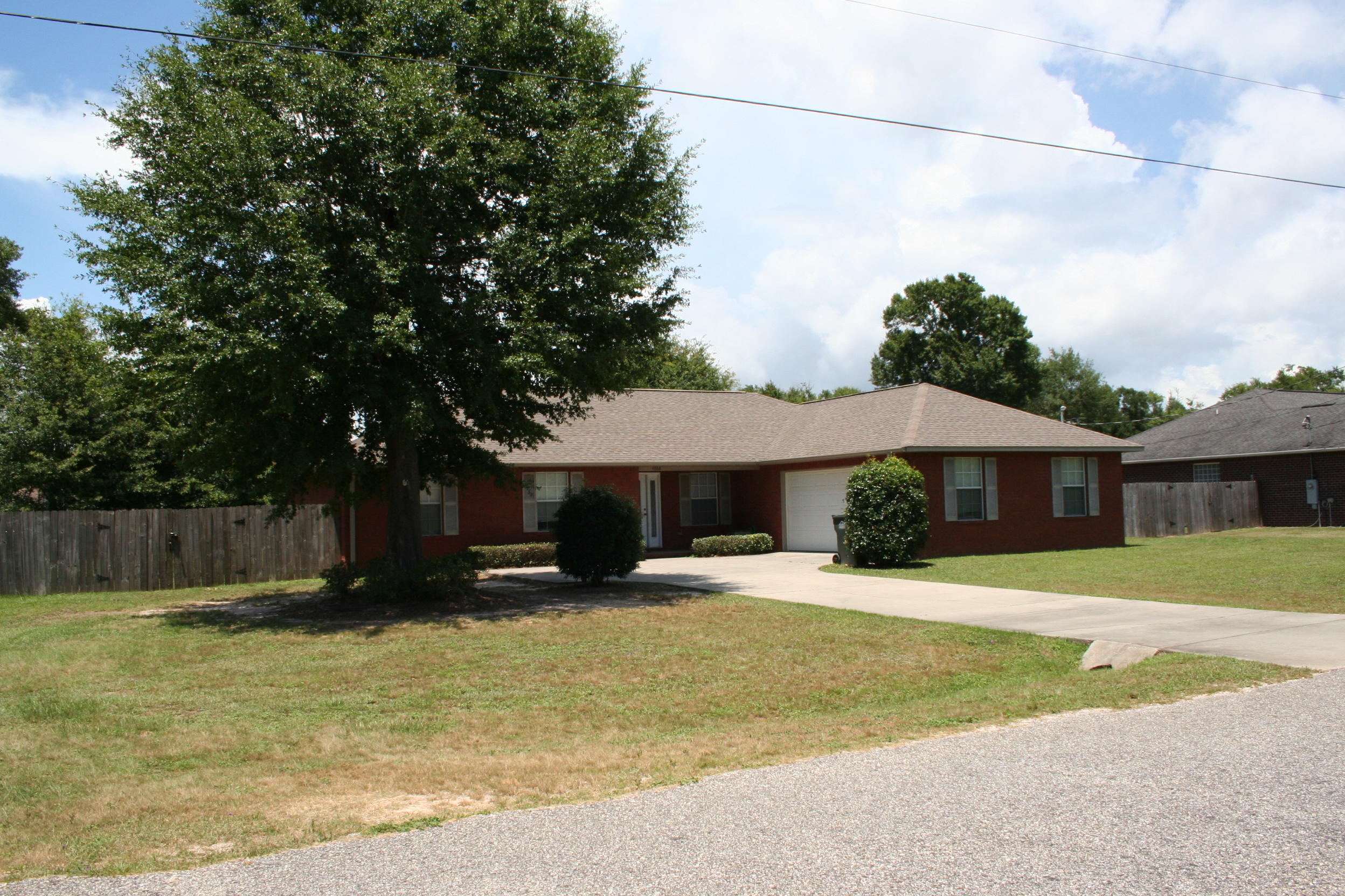4888 Jennifer Lane Pace, FL 32571 - Photo 1 of 10 a front view of a house with a yard garage and outdoor seating