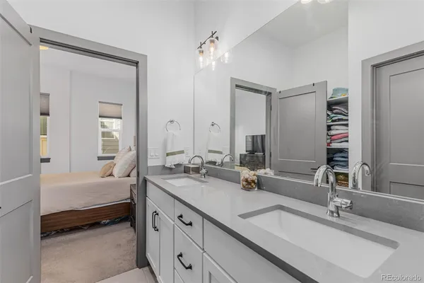 a bathroom with a double vanity sink a mirror and a bathtub