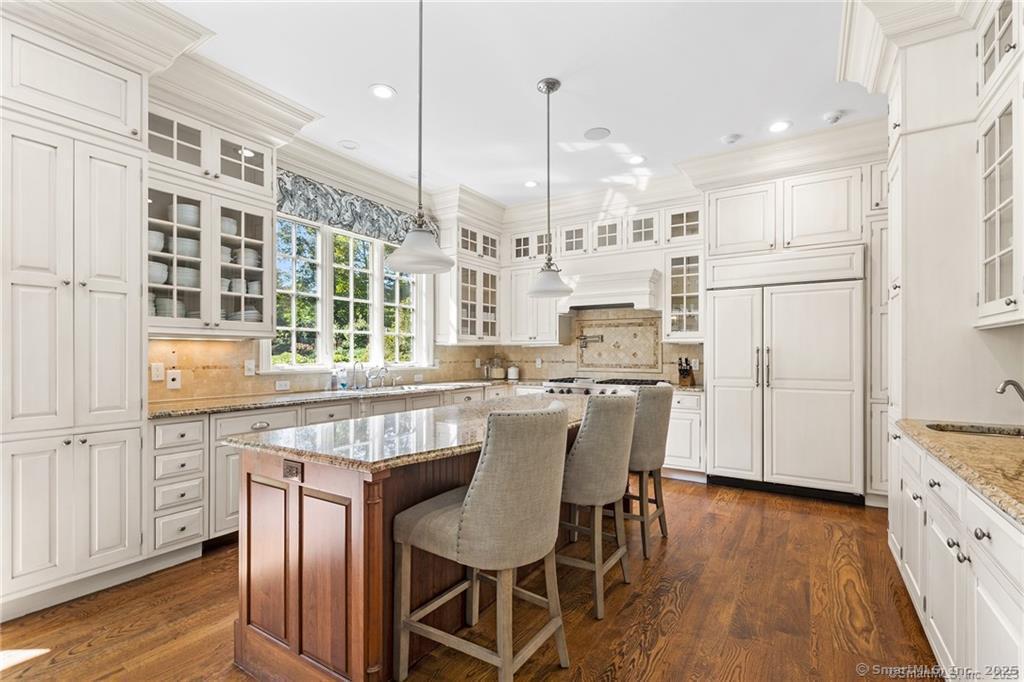 64 Old Redding Road Weston, CT 06883 - Photo 11 of 38 a kitchen with stainless steel appliances kitchen island granite countertop a table chairs and a refrigerator