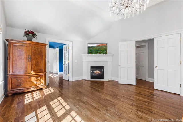 a view of a livingroom with wooden floor and a fireplace