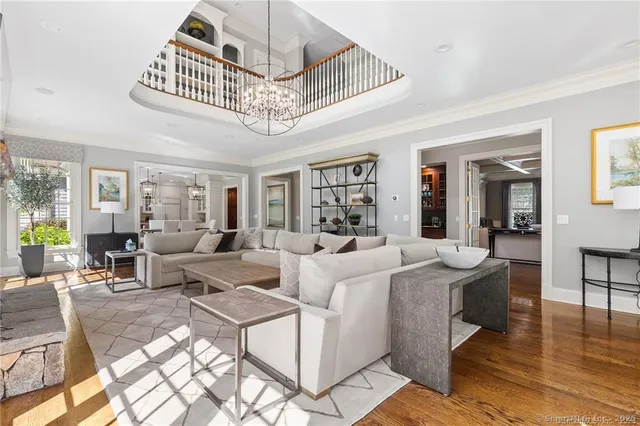 a living room with furniture a chandelier and a dining table