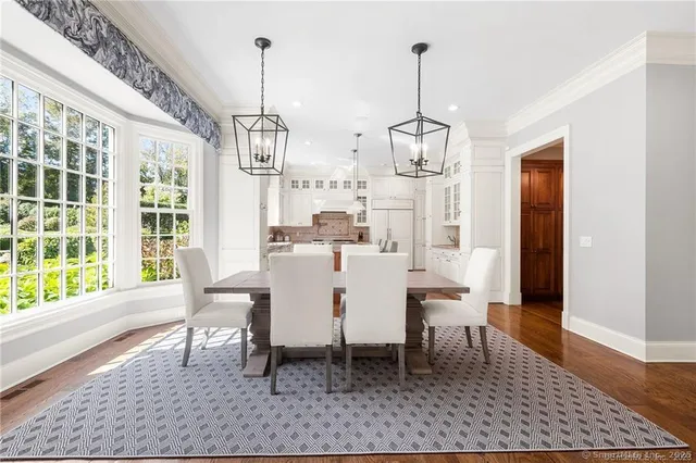 a dining room with furniture a chandelier and wooden floor